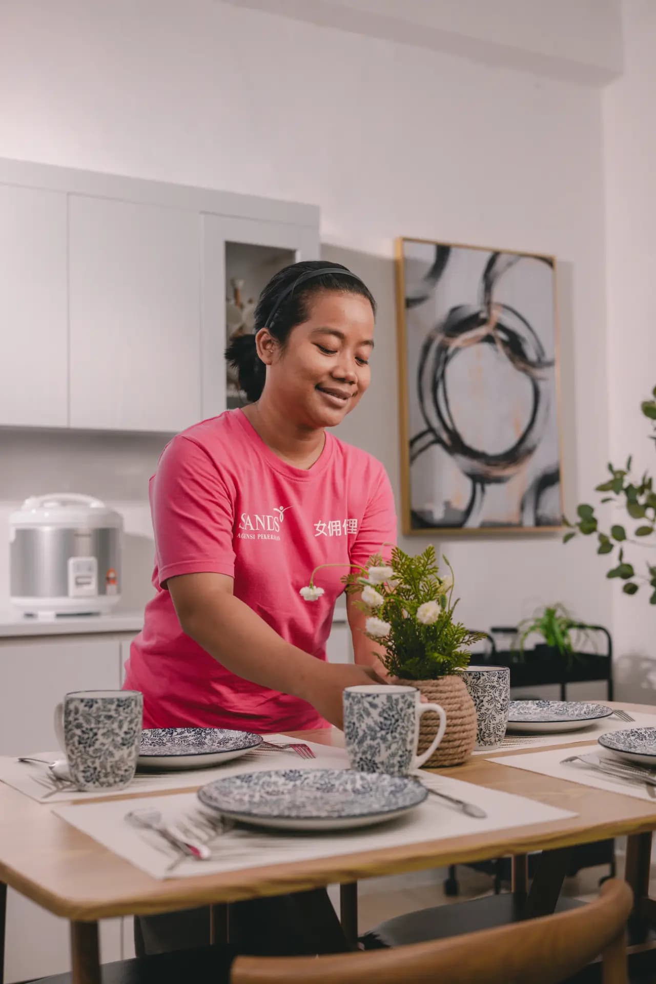 Domestic helper arranging items in kitchen